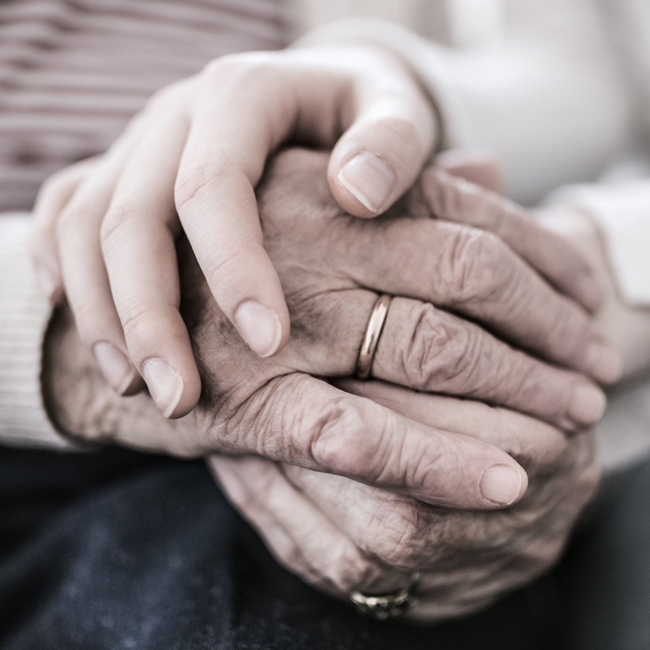 Hands of teenage girl and her grandmother at home.